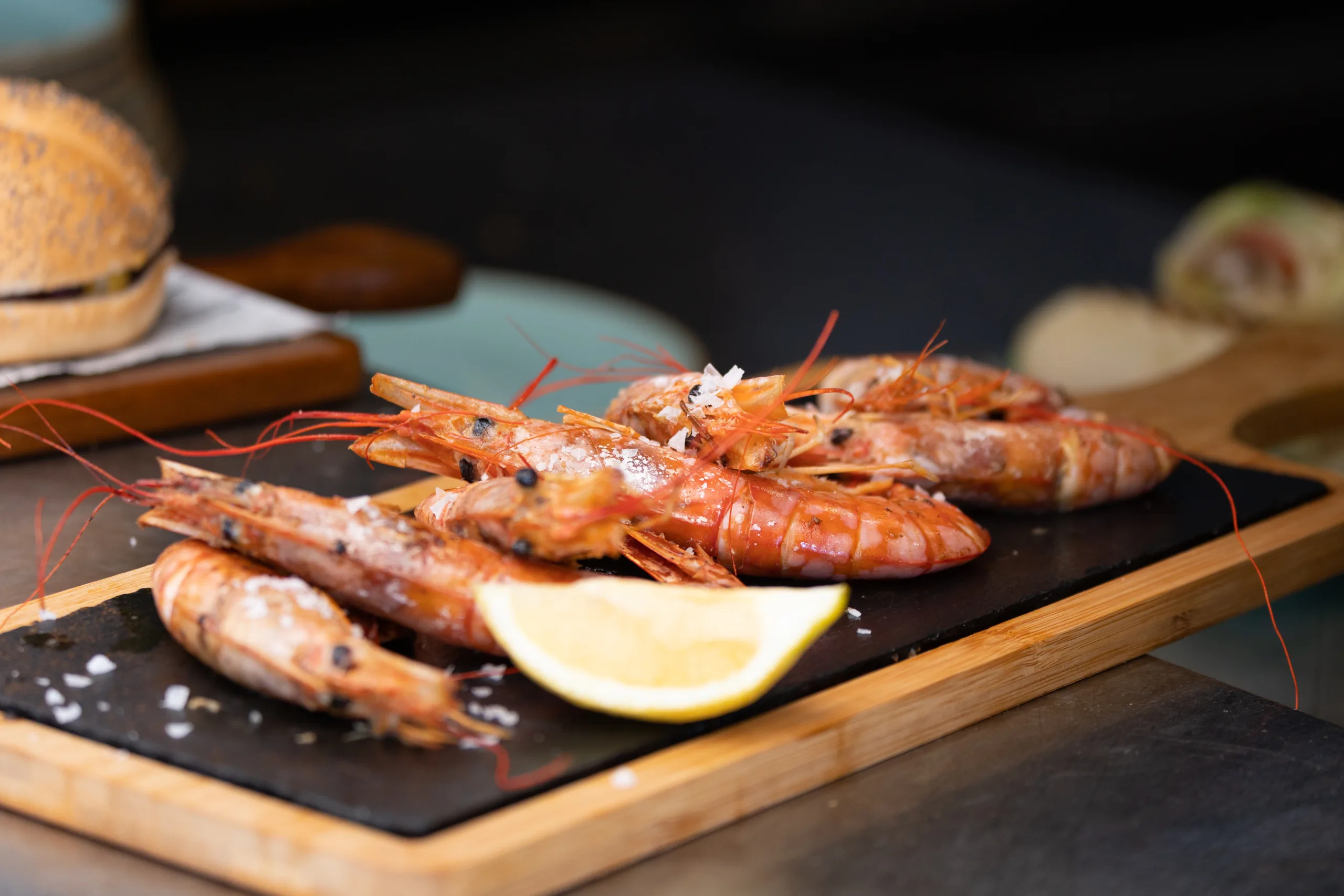 Grilled prawns with sea salt and lemon wedge served at The Point Marbella, a beachfront seafood restaurant.