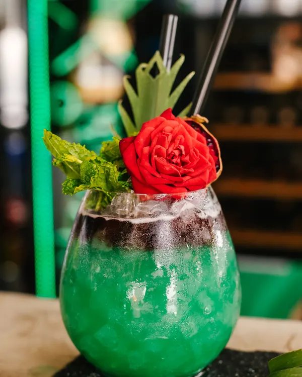 Cóctel verde decorado con una rosa en Marbella